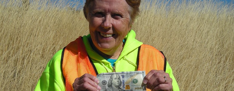 Gretchen Sherlin holds a $100 bill, found while collecting litter along ID-20
