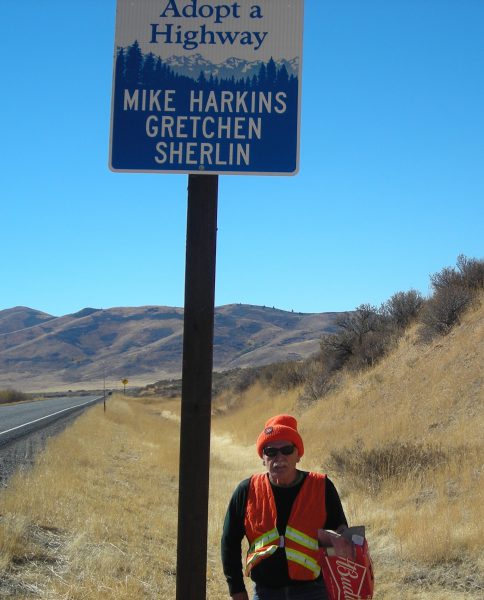 Mike Harkins stands beneath the Adopt-A-Highway sign with his and Gretchen's name