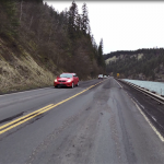 Car drives on deteriorating pavement on US-12 between Big Canyon (Peck) and Orofino