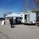Customers line up six feet apart at a food truck stationed on I-84 at Blacks Creek