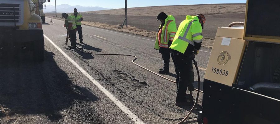 Four men on highway with jackhammers