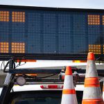 Image of sign in truck with cones in a work zone