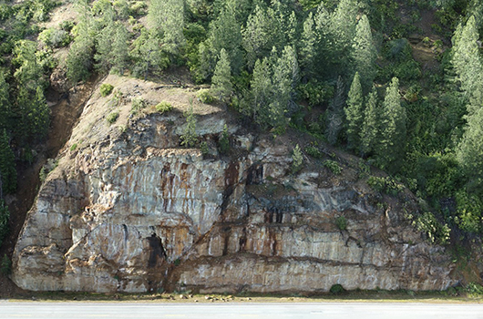 Rocky cliff face above US-2