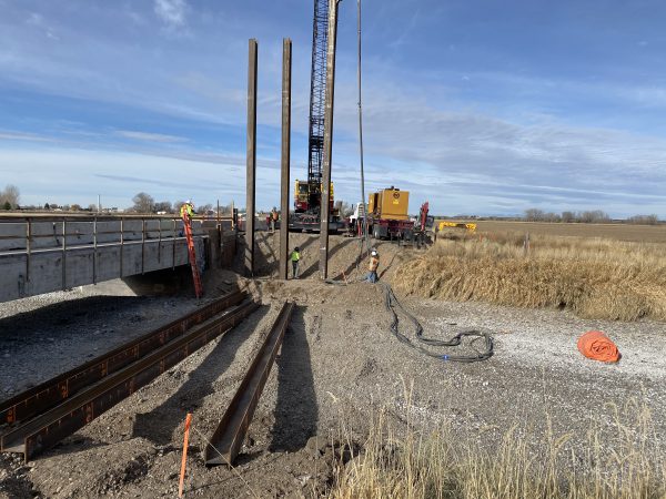 Construction crew driving piles with heavy equipment