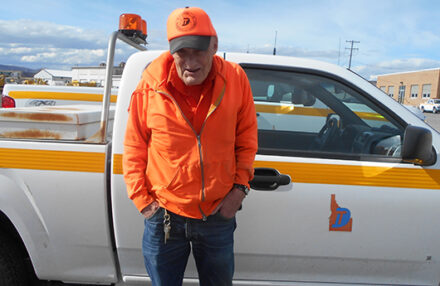 A man standing in front of a pickup truck.