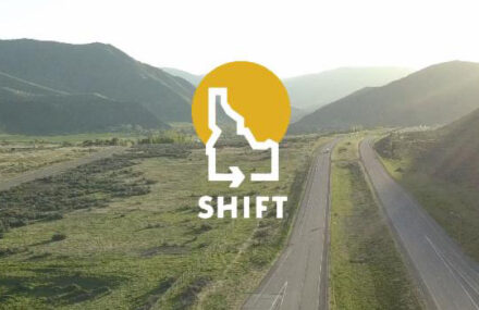 A highway with mountains in the background. The Shift logo is superimposed over the image.