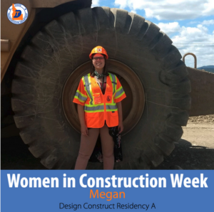A woman in a hard hat and vest in front of a giant tire.
