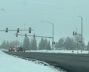 US-20 SH-47 snowy roadway and traffic signal in Ashton