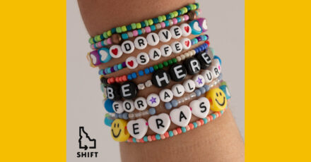 An arm with 10 stacked friendship bracelets