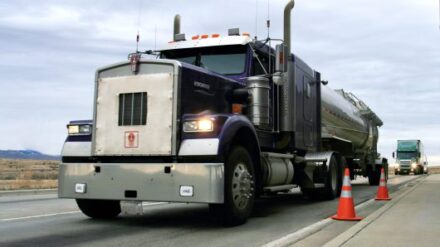 A semi truck parked beside orange cones.