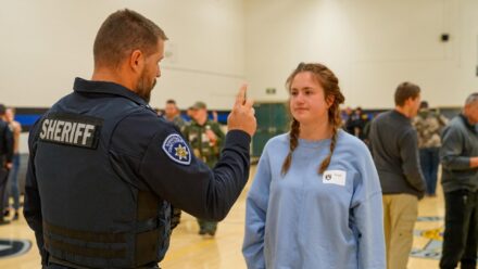An officer practices a field sobriety test with a volunteer.