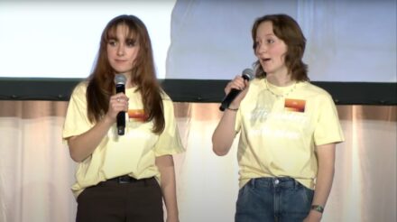 Two teen girls holding microphones.
