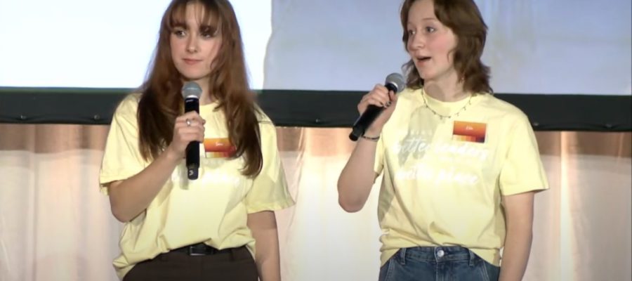 Two teen girls holding microphones.