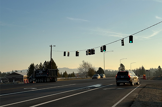 Sunset view behind intersection of SH-53 and Ramsey Road, showcasing temporary traffic signal overhead.
