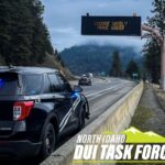 Police car in front of a digital sign encouraging people to drive sober