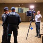 Police officers in front of a TV camera filming a commercial