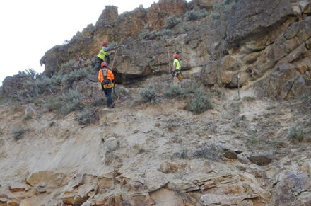 Scalers dislodging loose rock above the highway