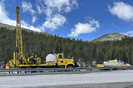 SH-33 Photo of a drilling rig and pickup truck working on roadside near the border of Idaho and Wyoming on Teton Pass