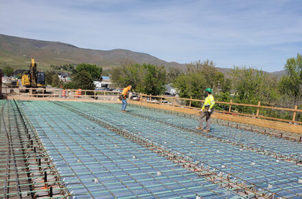 Workers on the US-12 Clearwater Memorial bridge walking over steel rebar.