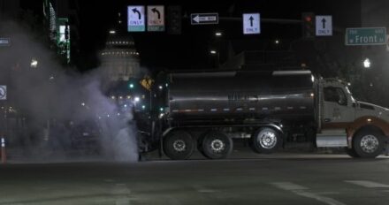 A chipsealing truck at night.