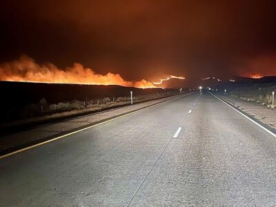 A highway with fire in the distance.
