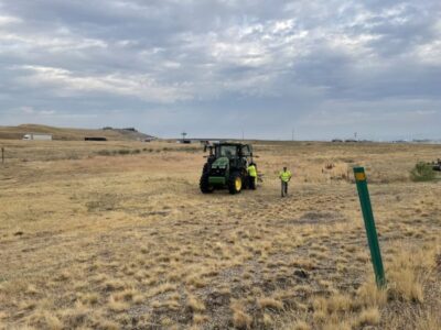 A worker from the ITD Mountain Home maintenance crew stands next to a mower.