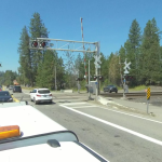 Traffic crosses a railroad crossing on SH-54