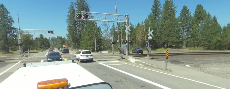 Traffic crosses a railroad crossing on SH-54