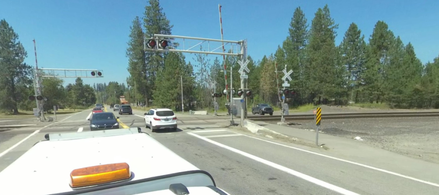 Traffic crosses a railroad crossing on SH-54