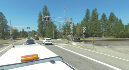 Traffic crosses a railroad crossing on SH-54