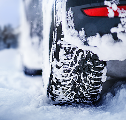 Vehicle's back tire on a snowy roadway