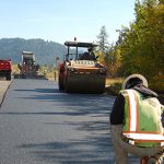 Paving, compacting and temperature testing occurring in Idaho with Fall leaves in the background.