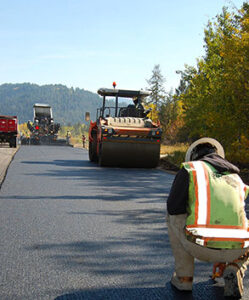 Paving, compacting and temperature testing occurring in Idaho with Fall leaves in the background.