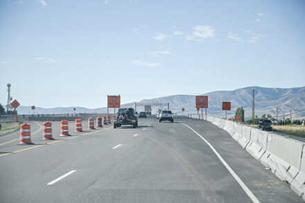 A highway with cones on one side and concrete barrier on the other.