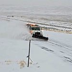 Snowplow on SH-28 plowing snow and creating a plume to the side.