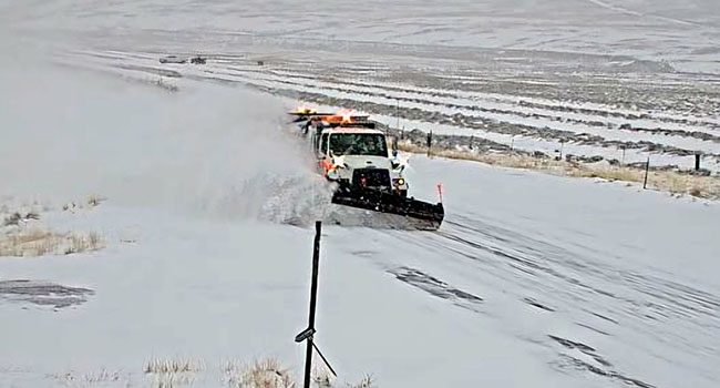 Snowplow on SH-28 plowing snow and creating a plume to the side.