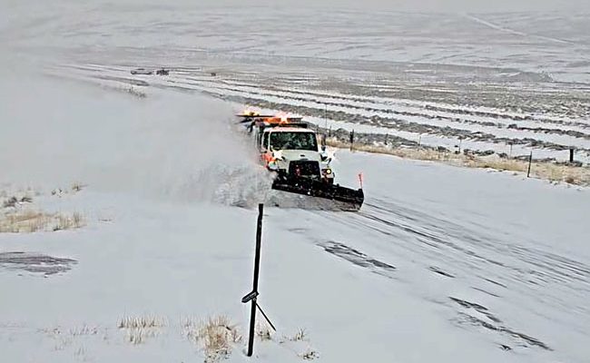 Snowplow on SH-28 plowing snow and creating a plume to the side.