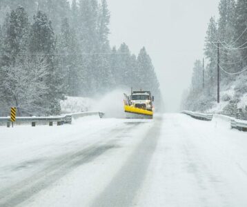 Snowplow clearing roadway on SH-21