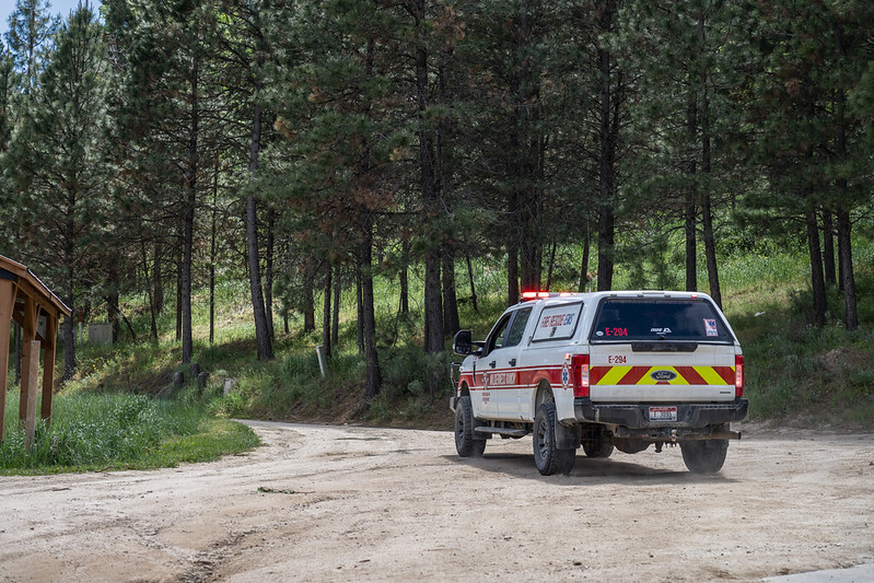 An EMS truck driving down a dirt road.
