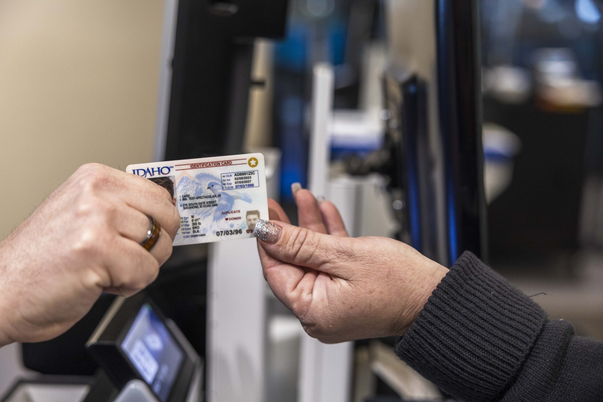 Two hands passing an Idaho Star Card between them.