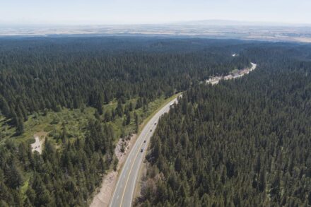 US-20 wide aerial view of this loosely winding mountain road through the Island Park area