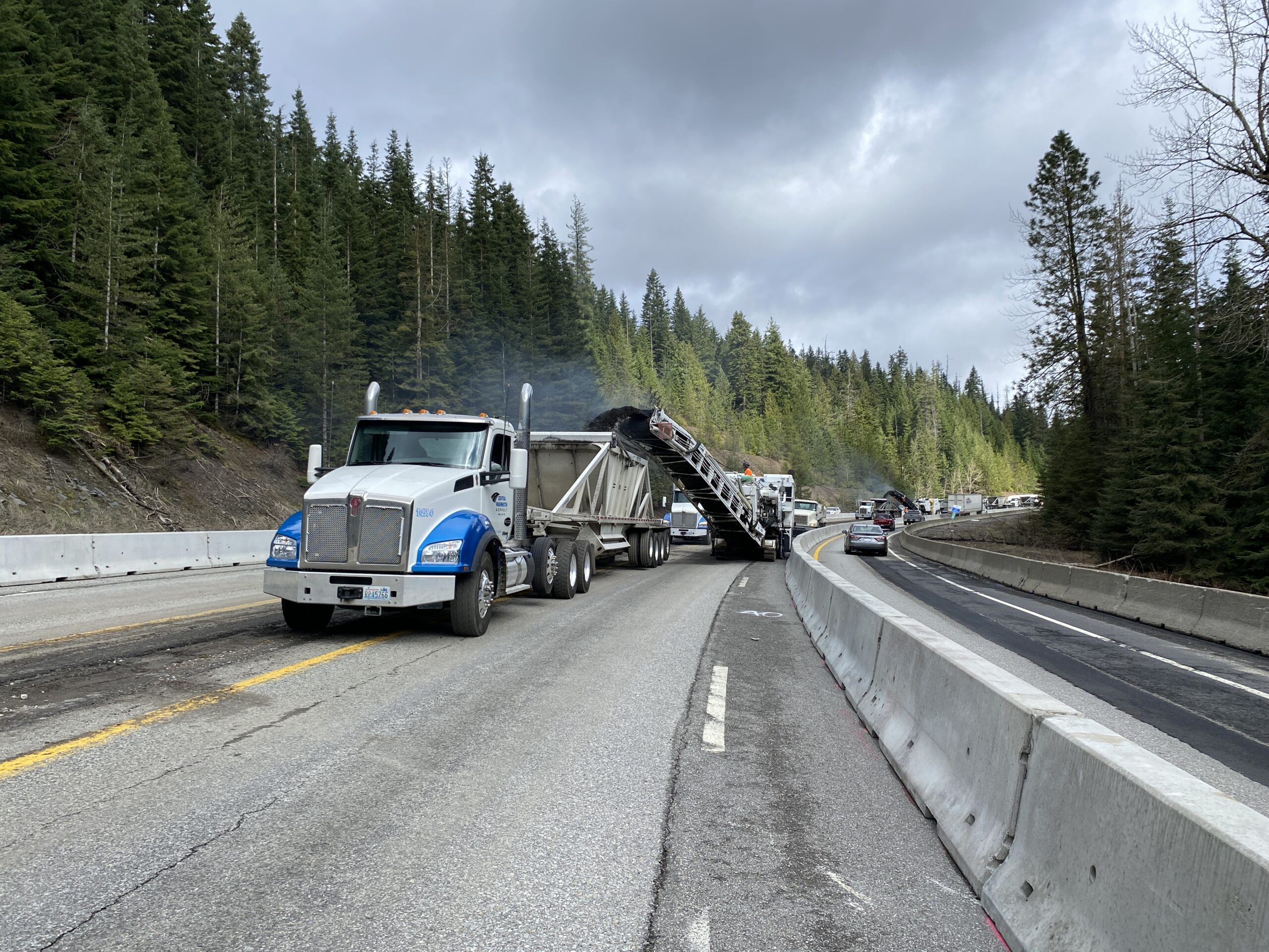 Semi-trucks loading and hauling away material milled from I-90 on Fourth of July Pass.