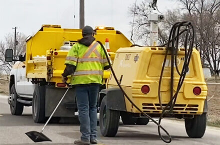 An ITD employee and a crack sealing truck.