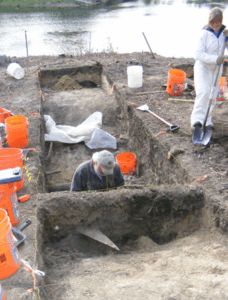Two people working in an archaeological dig site 