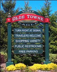 A sign for Olde Towne Eagle with directions and amenities.