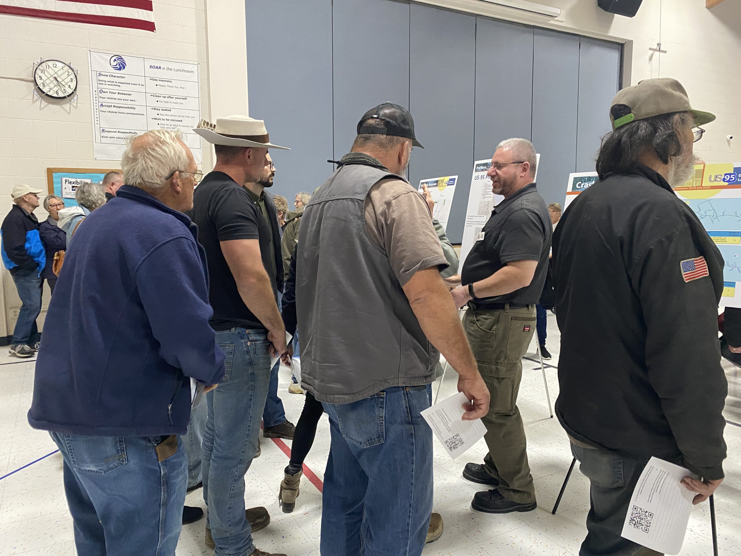 Members of the community gathered around display boards to learn about the project. 