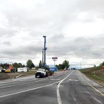 A drill rig and other equipment, as well as orange traffic control devices, at US-20 Exit 333 while work is being conducted.