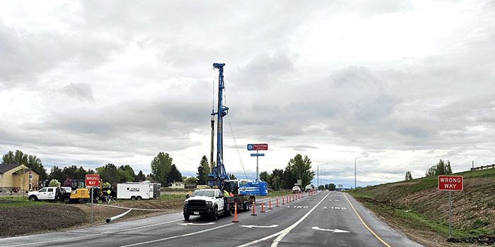 A drill rig and other equipment, as well as orange traffic control devices, at US-20 Exit 333 while work is being conducted.