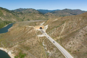 Aerial view of State Highway 21 wildlife overpass. The overpass is built structure over the roadway to allow wildlife to safely travel across the highway to navigate from the hillside to water access.