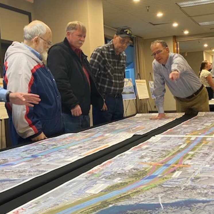 Members of the public reviewing project information at a public meeting.